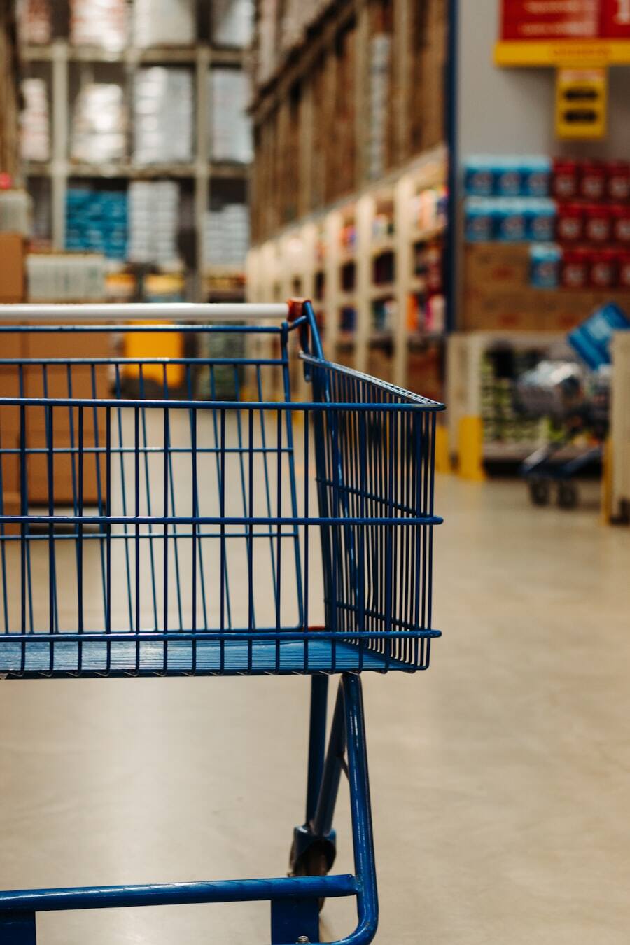 Shopping cart in a stocked grocery aisle